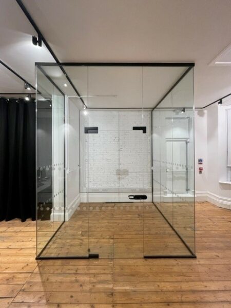 Large glass room partition with decorative industrial black piping