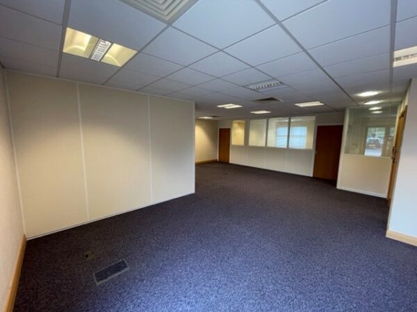 Large carpeted office space with office partitioning system creating three separate offices