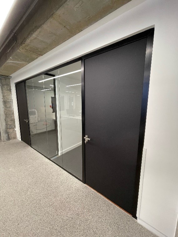 Modern meeting room with glass partitioning and black laminate doors